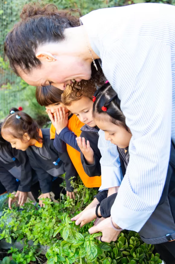 Profesora ensenyant als nens l'hort