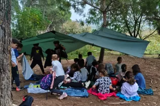 Alumnes de 3r de primària en una sessió d'escola bosc de Claver Natura en un dia de pluja