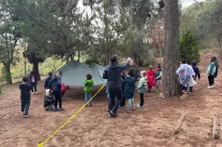 Alumnes de 3r de primària en una sessió d'escola bosc de Claver Natura en un dia de pluja